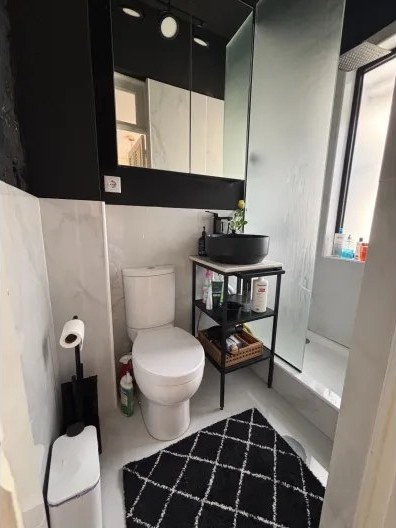 Bathroom with marble tiling and a walk-in shower