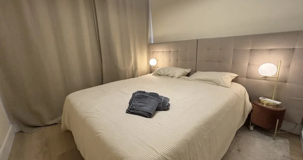 Bedroom with a tufted headboard and bedside lamps