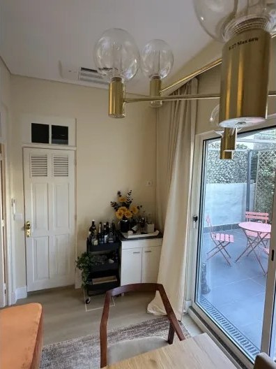 Dining nook with a brass chandelier and view to the terrace