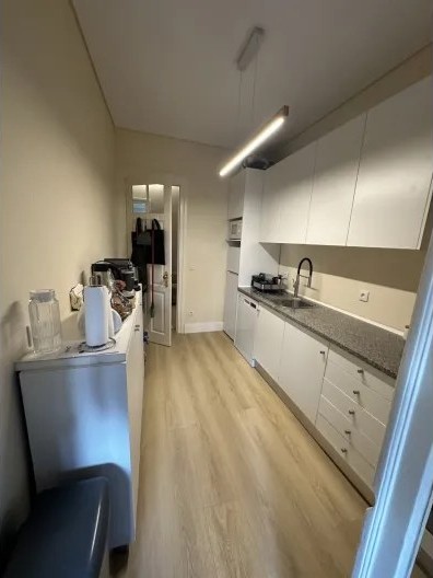 Galley kitchen with white cabinetry